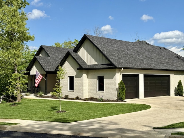 modern farmhouse style home with a garage, board and batten siding, a shingled roof, a front lawn, and driveway