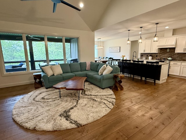 living room featuring lofted ceiling, hardwood / wood-style flooring, a ceiling fan, and recessed lighting