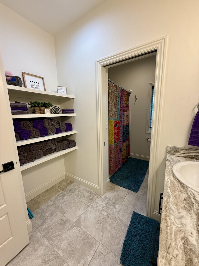 full bathroom featuring tile patterned flooring, vanity, baseboards, and a shower with curtain