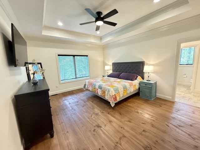 bedroom with a raised ceiling, ornamental molding, light wood-type flooring, baseboards, and recessed lighting