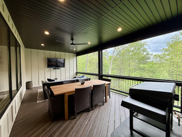 sunroom / solarium with healthy amount of natural light, a ceiling fan, and outdoor dining area