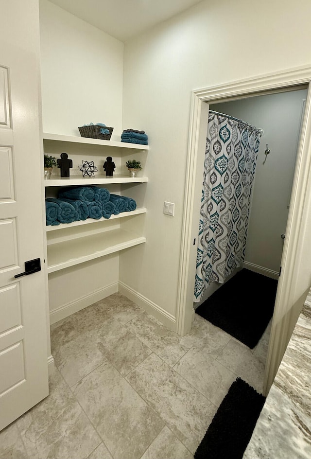 full bath featuring baseboards and a shower with curtain