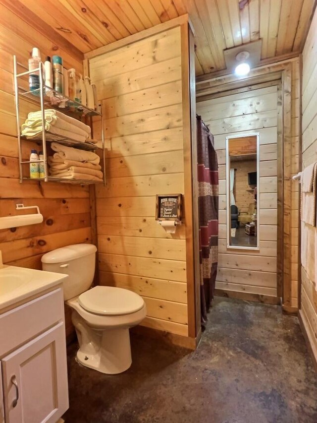1424 Brown Rd, Van Buren, MO 63965 - bathroom with wooden walls, wooden ceiling, unfinished concrete flooring, toilet, and vanity