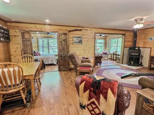 1424 Brown Rd, Van Buren, MO 63965 - living area with wooden walls, a wood stove, wood finished floors, a ceiling fan, and recessed lighting