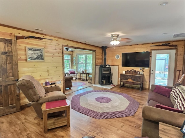 1424 Brown Rd, Van Buren, MO 63965 - living room with wooden walls, a wood stove, wood finished floors, and a ceiling fan