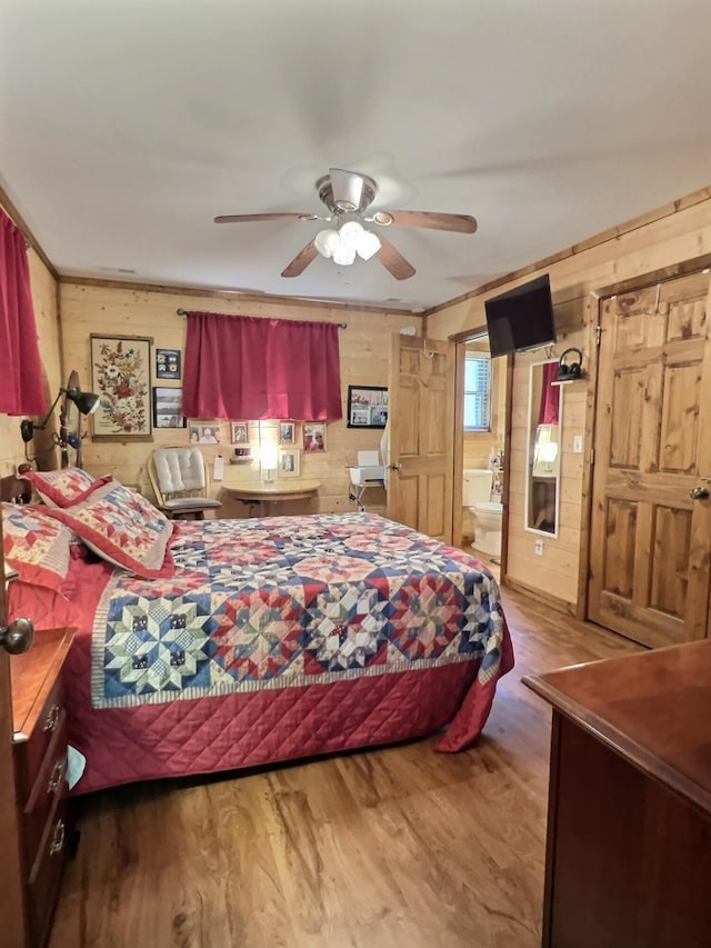 1424 Brown Rd, Van Buren, MO 63965 - bedroom featuring wooden walls, wood finished floors, ceiling fan, and connected bathroom