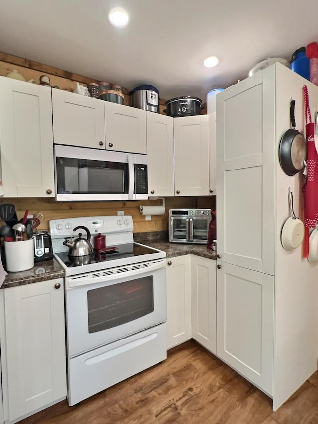 1424 Brown Rd, Van Buren, MO 63965 - kitchen with white range with electric cooktop, dark countertops, light wood-style floors, white cabinets, and recessed lighting