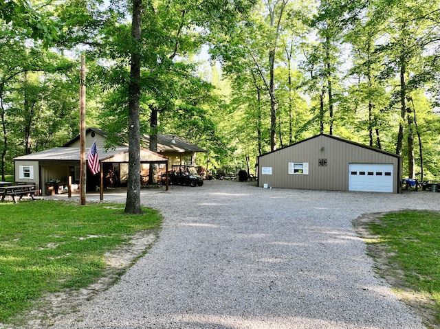 1424 Brown Rd, Van Buren, MO 63965 - view of home's exterior featuring a detached garage, gravel driveway, view of scattered trees, and an outbuilding