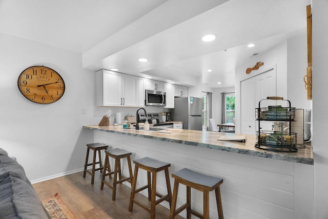 77 Anglers Pointe Unit 4, Branson, MO 65616 - kitchen featuring stainless steel appliances, a peninsula, wood finished floors, baseboards, and recessed lighting