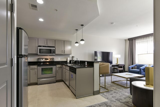 2312 Branson Landing Blvd Unit A, Branson, MO 65616 - kitchen featuring appliances with stainless steel finishes, gray cabinets, open floor plan, dark countertops, and a peninsula