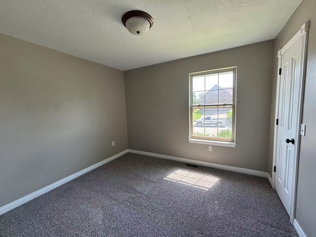 carpeted empty room featuring baseboards