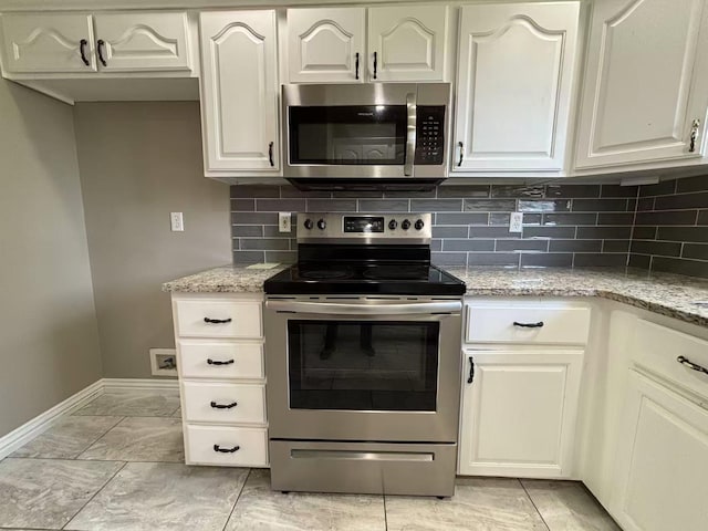 kitchen featuring stainless steel appliances, baseboards, tasteful backsplash, light stone countertops, and white cabinets