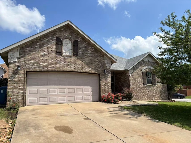 view of front facade with driveway and brick siding