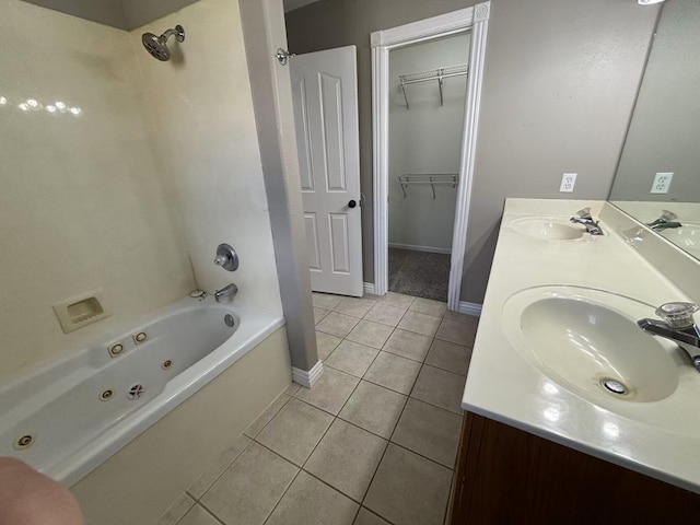 bathroom with tile patterned floors, a combined bath / shower with jetted tub, baseboards, double vanity, and a walk in closet