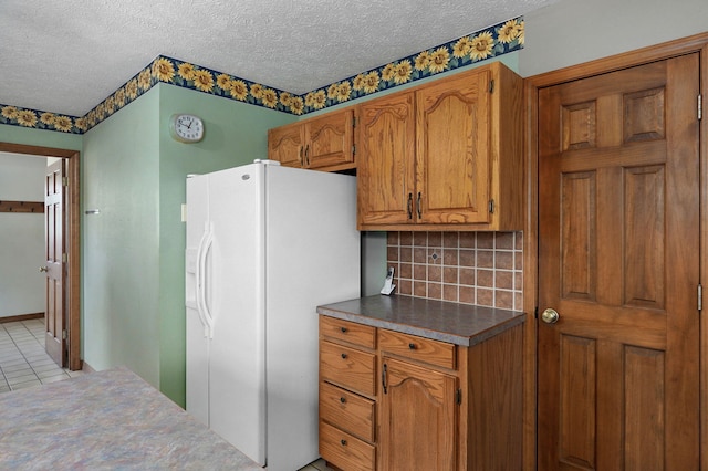 13860 Lawrence Unit 1158, Mount Vernon, MO 65712 - kitchen featuring white refrigerator with ice dispenser, brown cabinetry, decorative backsplash, a textured ceiling, and light tile patterned flooring