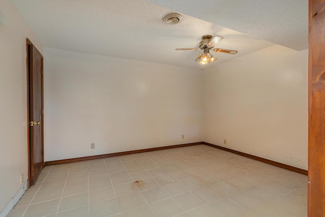 empty room with ceiling fan, baseboards, and a textured ceiling