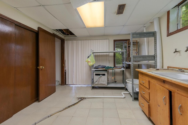 bathroom with a paneled ceiling, vanity, and tile patterned floors