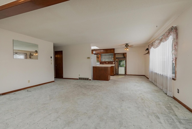 unfurnished living room featuring baseboards, light carpet, and ceiling fan