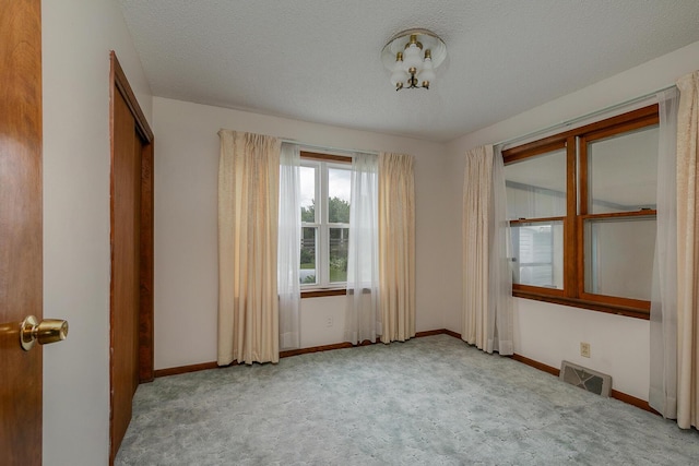 carpeted spare room featuring baseboards