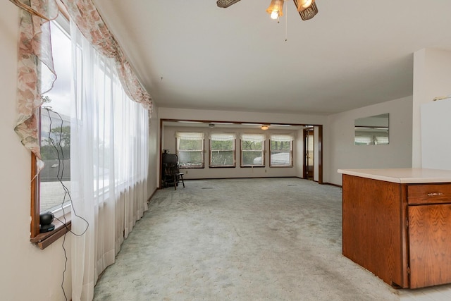 unfurnished living room featuring ceiling fan and light colored carpet