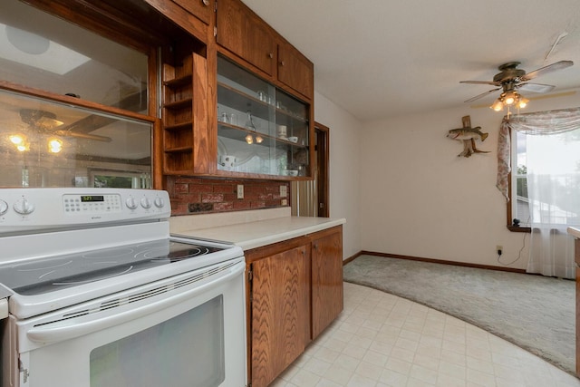 kitchen featuring white electric range, light colored carpet, brown cabinetry, and light countertops