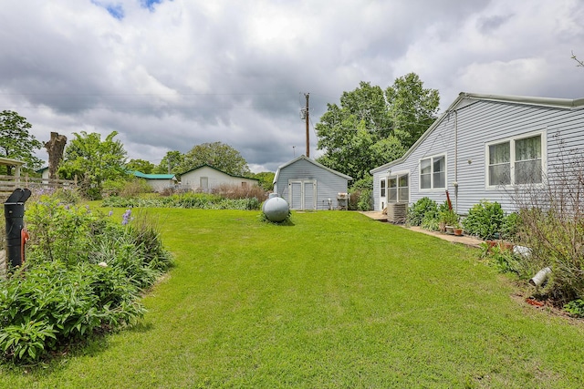 view of grassy yard with an outdoor structure