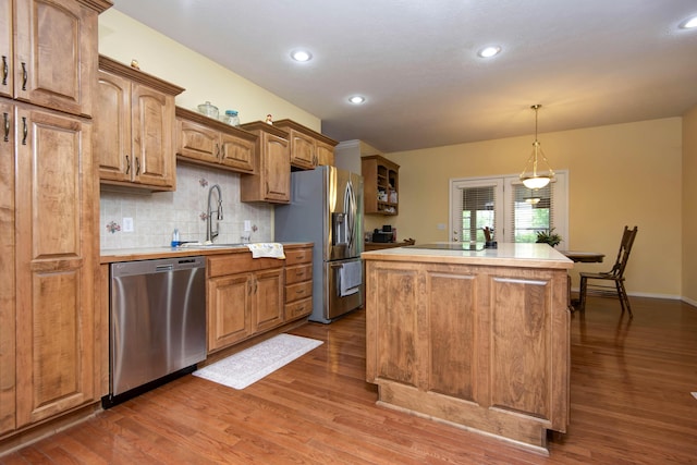 904 W Crater Cir, Nixa, MO 65714 - kitchen with stainless steel appliances, a sink, light countertops, a kitchen island, and dark wood-style flooring