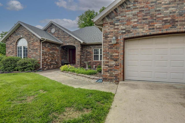 904 W Crater Cir, Nixa, MO 65714 - view of front facade featuring a front lawn, a shingled roof, brick siding, an attached garage, and driveway