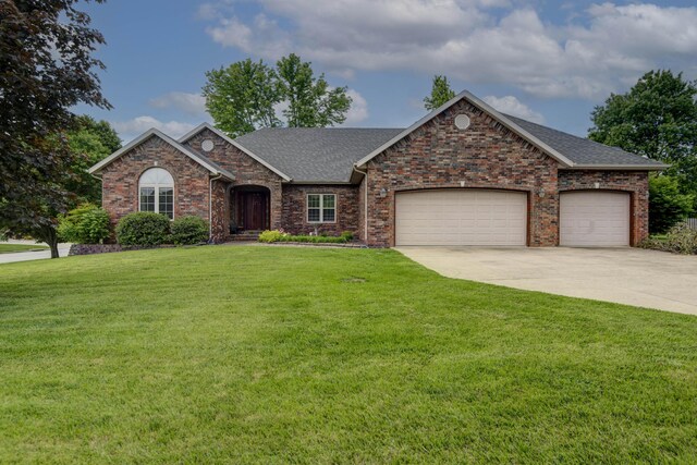 904 W Crater Cir, Nixa, MO 65714 - view of front of house with a front lawn, driveway, an attached garage, roof with shingles, and brick siding