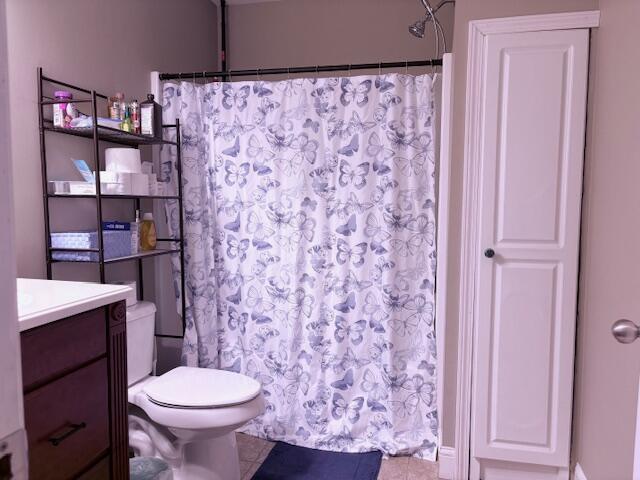 full bath with toilet, vanity, curtained shower, and tile patterned flooring
