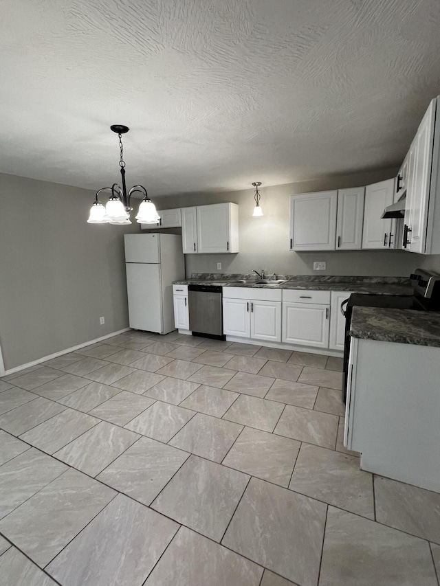 kitchen featuring freestanding refrigerator, stainless steel dishwasher, dark countertops, white cabinets, and baseboards