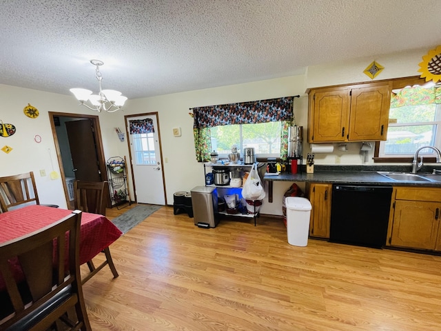 kitchen with dishwasher, a sink, a chandelier, light wood finished floors, and plenty of natural light