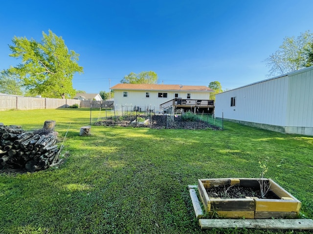 view of yard featuring a vegetable garden, stairs, and a wooden deck