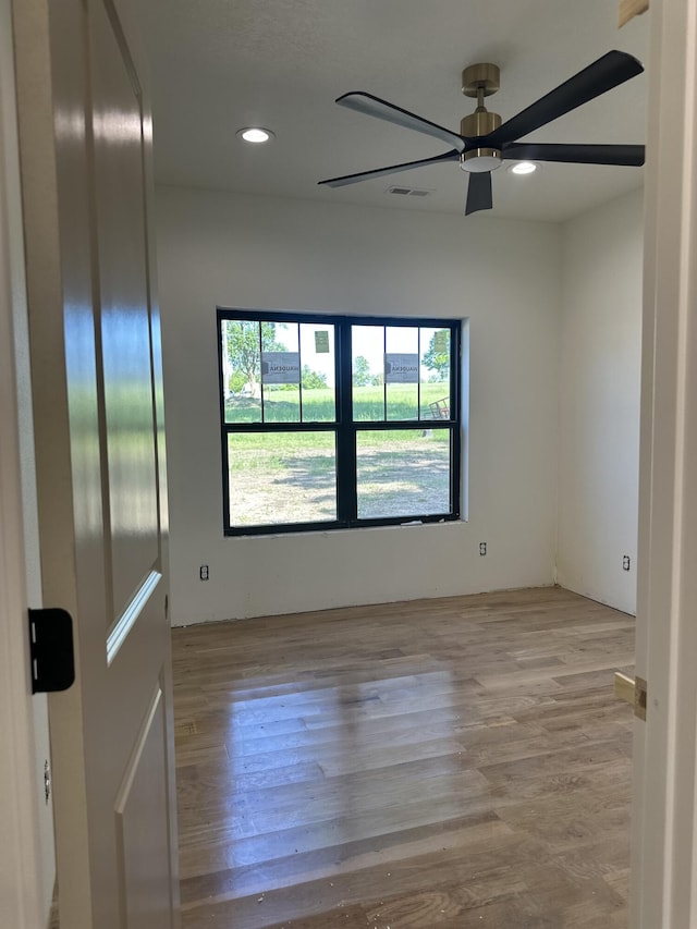 spare room featuring healthy amount of natural light, a ceiling fan, wood finished floors, and recessed lighting