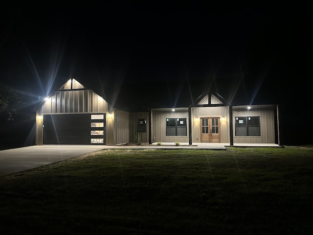 view of front facade with french doors, board and batten siding, concrete driveway, and an attached garage