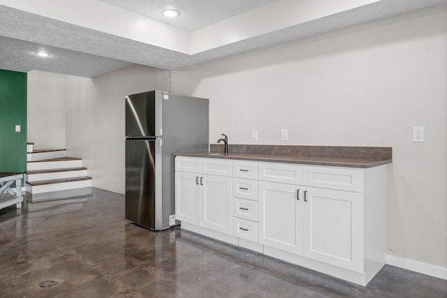 5376 S 140th Rd, Morrisville, MO 65710 - kitchen featuring dark countertops, white cabinets, freestanding refrigerator, a sink, and finished concrete flooring