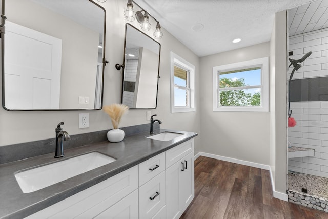 5376 S 140th Rd, Morrisville, MO 65710 - bathroom featuring a tile shower, baseboards, wood finished floors, and double vanity