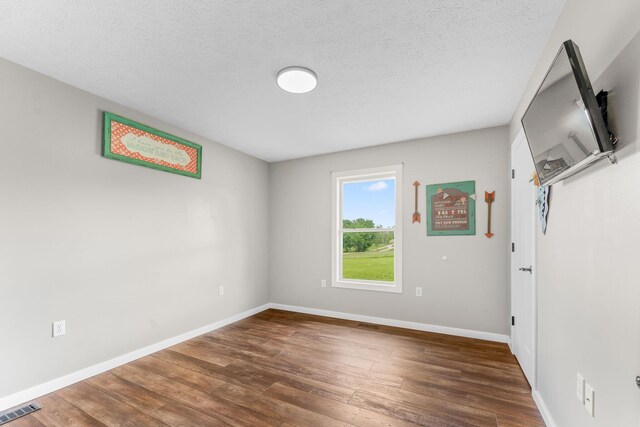 5376 S 140th Rd, Morrisville, MO 65710 - unfurnished room featuring wood finished floors, baseboards, and a textured ceiling
