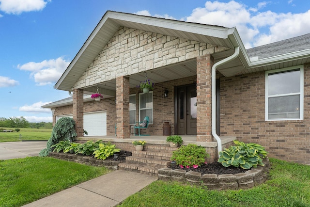 5376 S 140th Rd, Morrisville, MO 65710 - view of front of home featuring covered porch, concrete driveway, a garage, brick siding, and a shingled roof