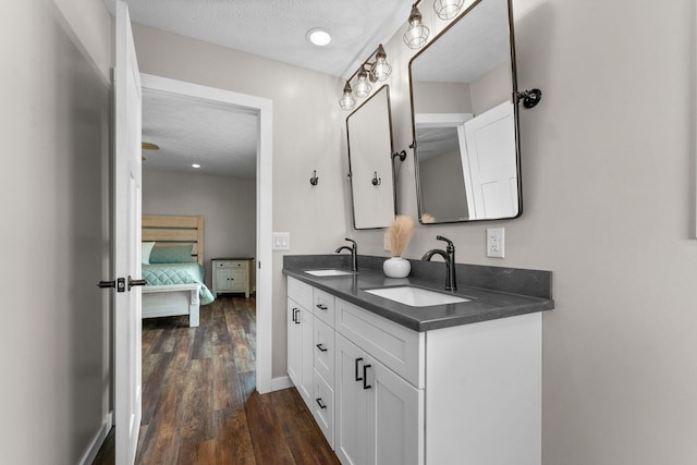 5376 S 140th Rd, Morrisville, MO 65710 - bathroom with wood finished floors, double vanity, ensuite bath, a textured ceiling, and baseboards