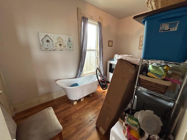 laundry room featuring wood finished floors and baseboards