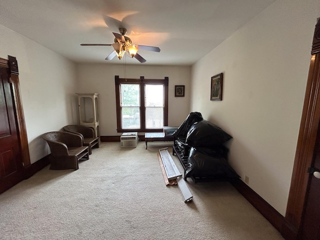 sitting room with ceiling fan, carpet floors, and baseboards