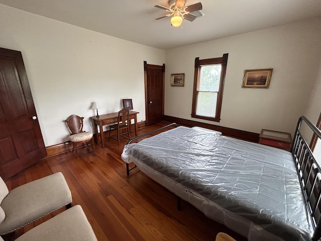 bedroom with baseboards, wood finished floors, and a ceiling fan