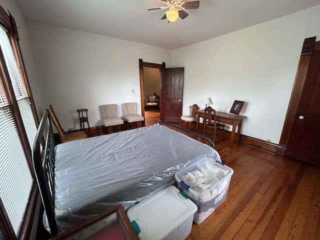 bedroom featuring wood finished floors, baseboards, and a ceiling fan