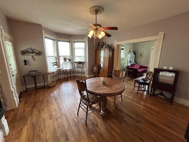 dining area with wood finished floors, ceiling fan, and baseboards