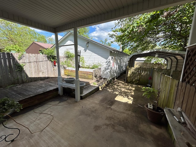 view of patio / terrace featuring fence and a detached carport