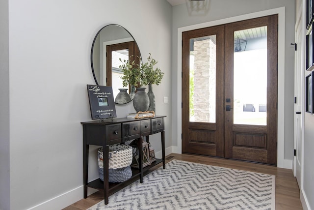 entrance foyer featuring french doors, wood finished floors, and baseboards
