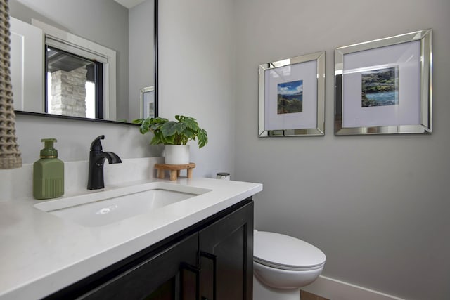 half bathroom with toilet and vanity