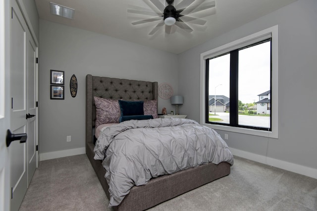 carpeted bedroom featuring baseboards and ceiling fan