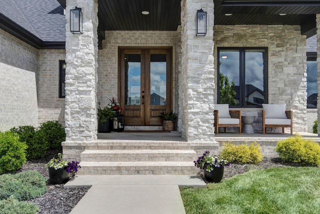 doorway to property with french doors, a porch, and stone siding